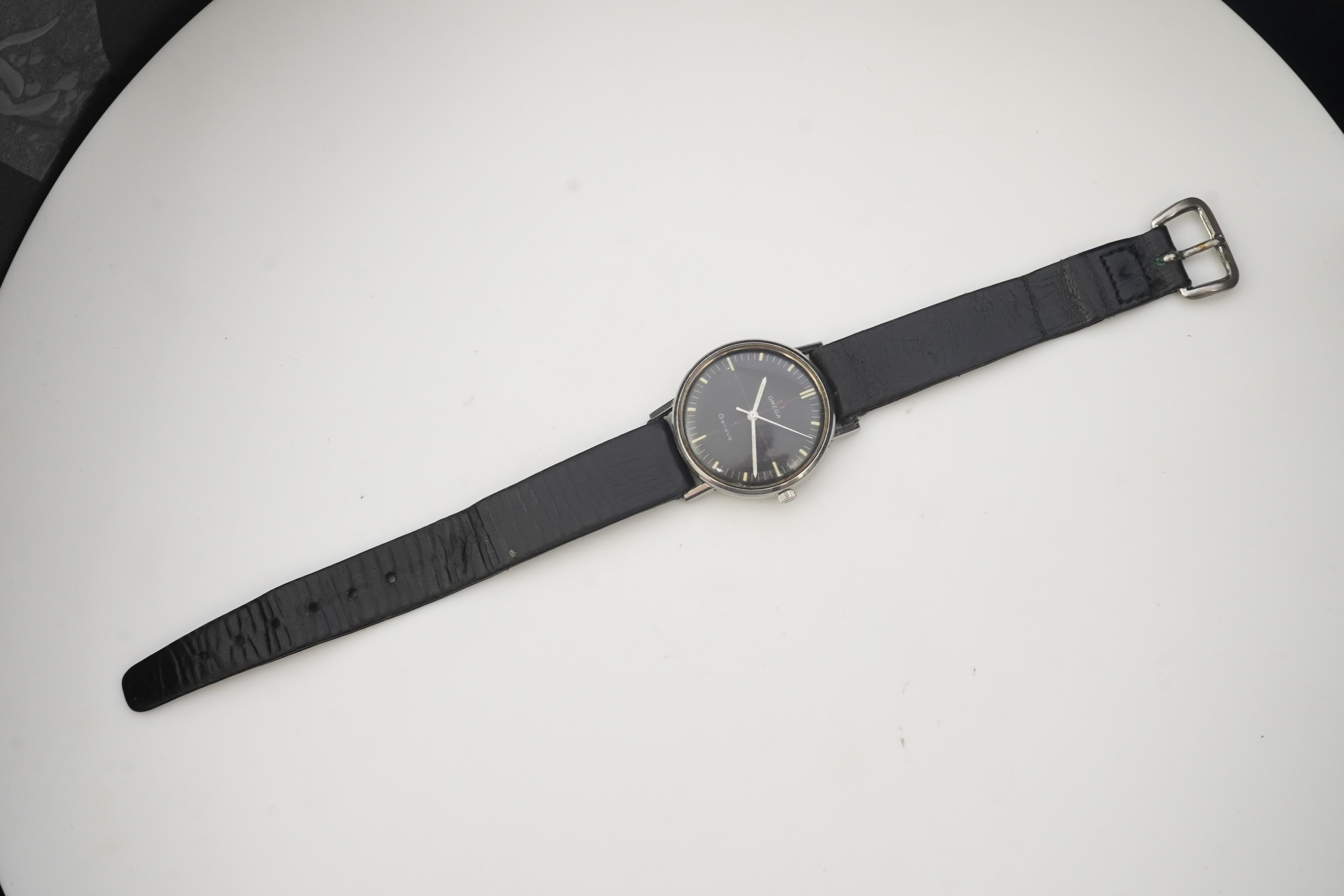 A gentleman's late 1960's/early 1970's stainless steel Omega manual wind wrist watch, the black dial with red cross-hair and baton numerals